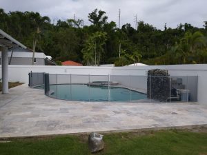 Pool Barrier Maintenance Pool fence around free form pool on travertine deck with rock wall