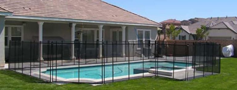 A backyard pool in San Diego is enclosed by a black mesh pool fence, ensuring child and pet safety while maintaining an unobstructed view.
