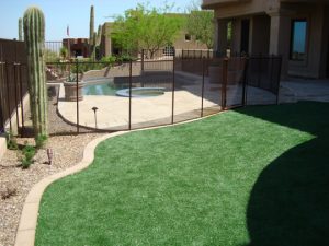 Brown mesh pool fence enclosing desert-style backyard pool in Houston TX
