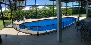 Mesh pool fence installed around a tear shaped swimming pool for child safety in Broward County