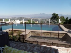 Black mesh pool fence around infinity pool in Orange County