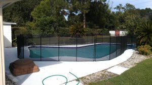 Mesh pool fence enclosing backyard swimming area in Lakeland Florida