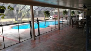 Orlando pool fence installed between a patio walkway and the pool area