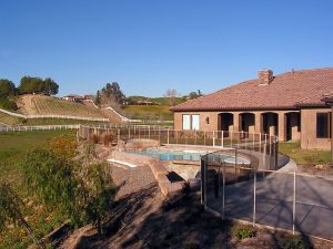 Pool fence surrounding a backyard pool in Orange County