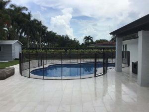 Black mesh pool fence in Palm Beach enclosing a backyard swimming area