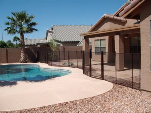 Brown mesh pool fence installation around backyard swimming pool in Houston, TX