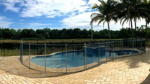 Black mesh pool fence around a curved swimming pool in Miami