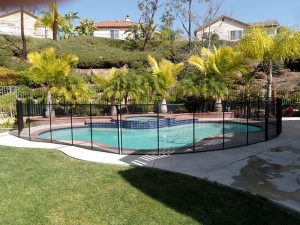 Pool fence in an Orange County backyard with palm trees