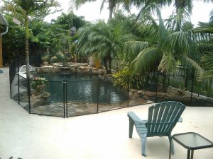 Mesh pool fence installed near patio furniture in an Orlando backyard