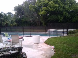 Black mesh pool fence installed around a backyard pool in Orlando