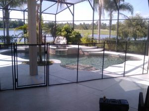 Black mesh pool fence installed near lakefront patio in Orlando