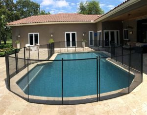 Black mesh pool fence surrounding a grecian backyard pool in Palm Beach