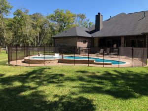 Brown mesh pool safety fence in large Houston backyard