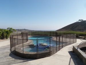 Scenic backyard pool in Orange County with black mesh safety fence