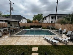 White mesh pool fence installation surrounding a modern rectangular pool in Houston backyard