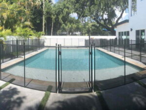 Black mesh pool fence installed around curved backyard pool in Jacksonville Florida