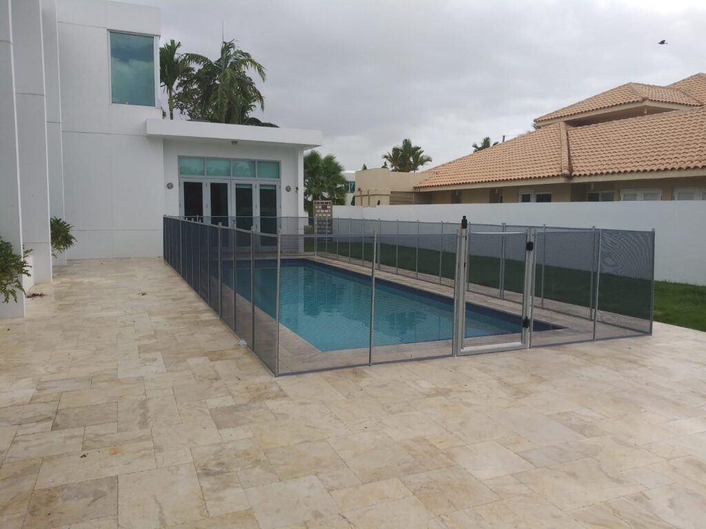 Luxury home pool secured with a removable mesh fence for child safety and pool protection