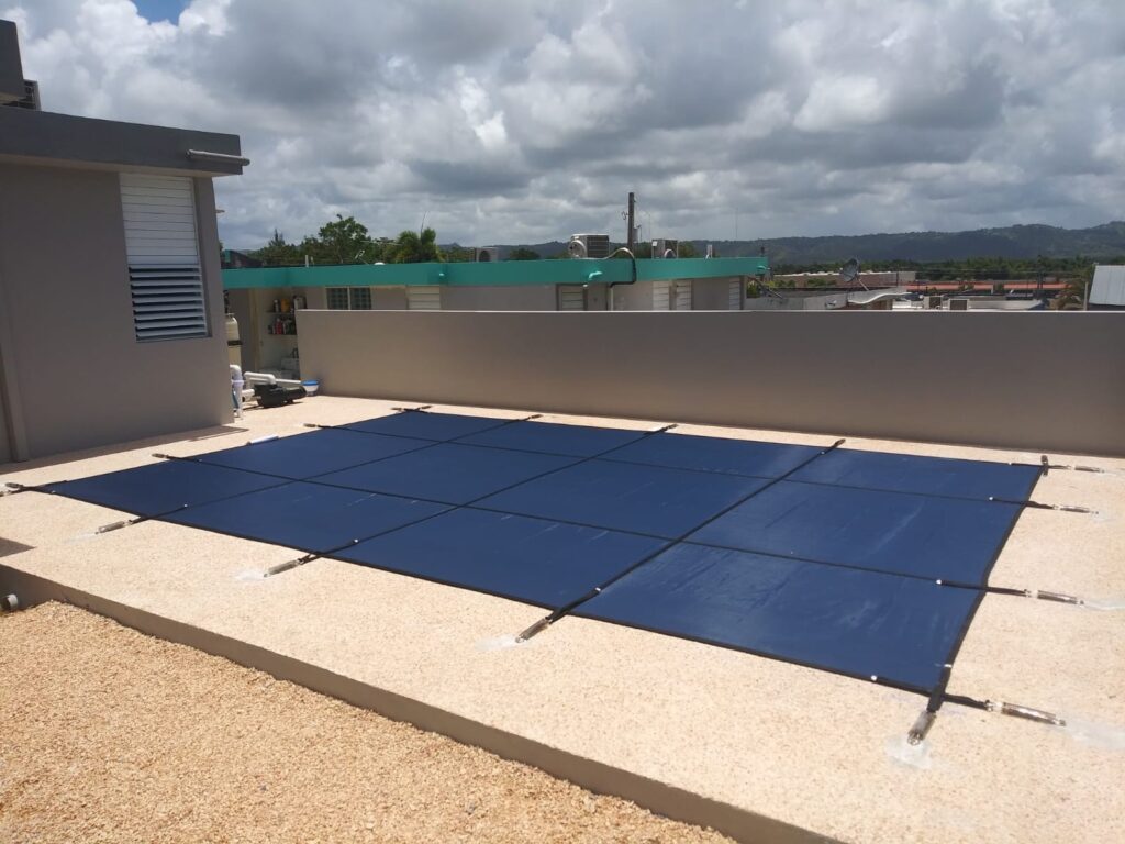 Pool covered with a blue safety cover on rooftop pool for seasonal protection