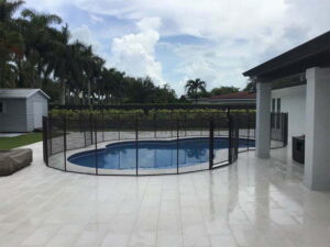 Black mesh pool fence installed around free form swimming pool in Ocala