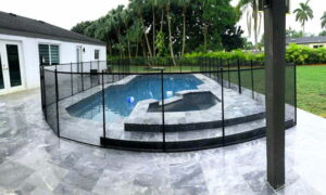 Black mesh pool fence around modern pool in Ocala, Florida with gray tiled deck