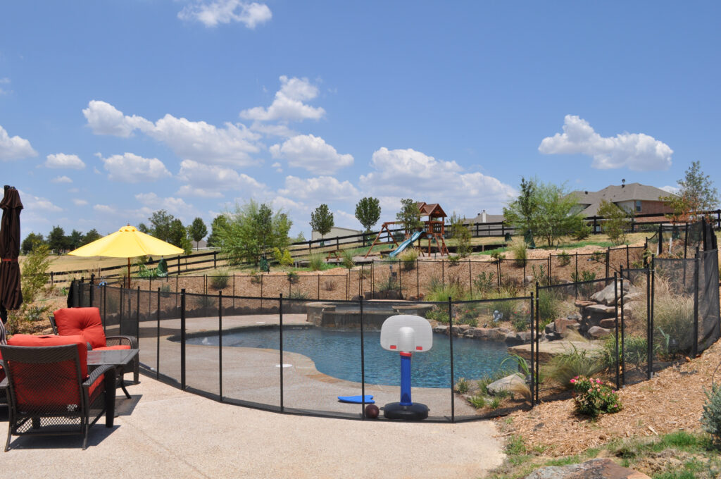 Pool safety fence installed around backyard pool in California with play area and safety features