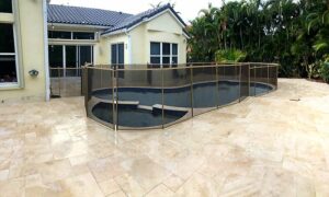 Elegant pool safety fence installation in Ocala Florida with brown mesh panels around a modern free form pool