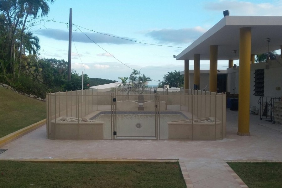 Transparent pool safety fence installed around pool area with clear views and secure gate access