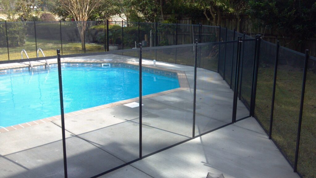 Black mesh pool fence installed around a pool in New York to meet safety requirements