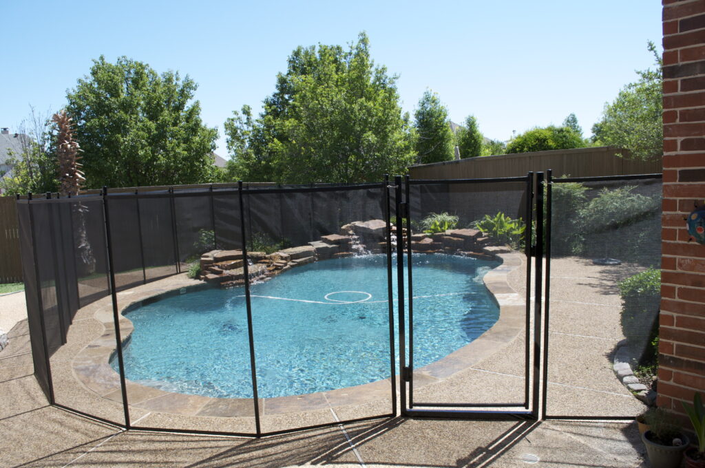 Texas pool fence installation with black mesh around the pool area, ensuring safety and compliance with local regulations.