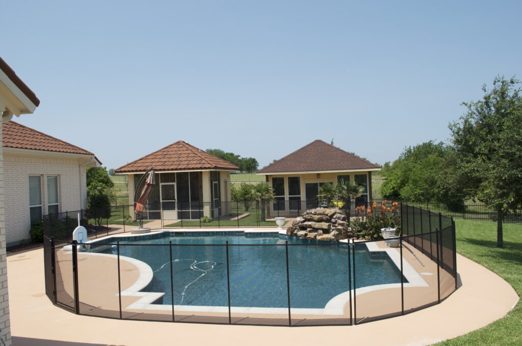 Backyard pool with mesh safety fence built for Las Vegas weather, featuring heat-resistant materials and desert-style landscaping