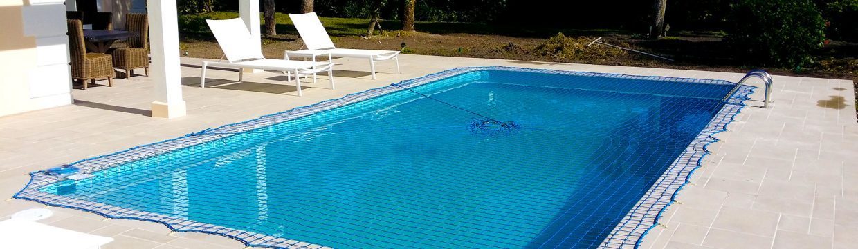 Blue pool net cover installed over residential swimming pool by Pool Guard USA